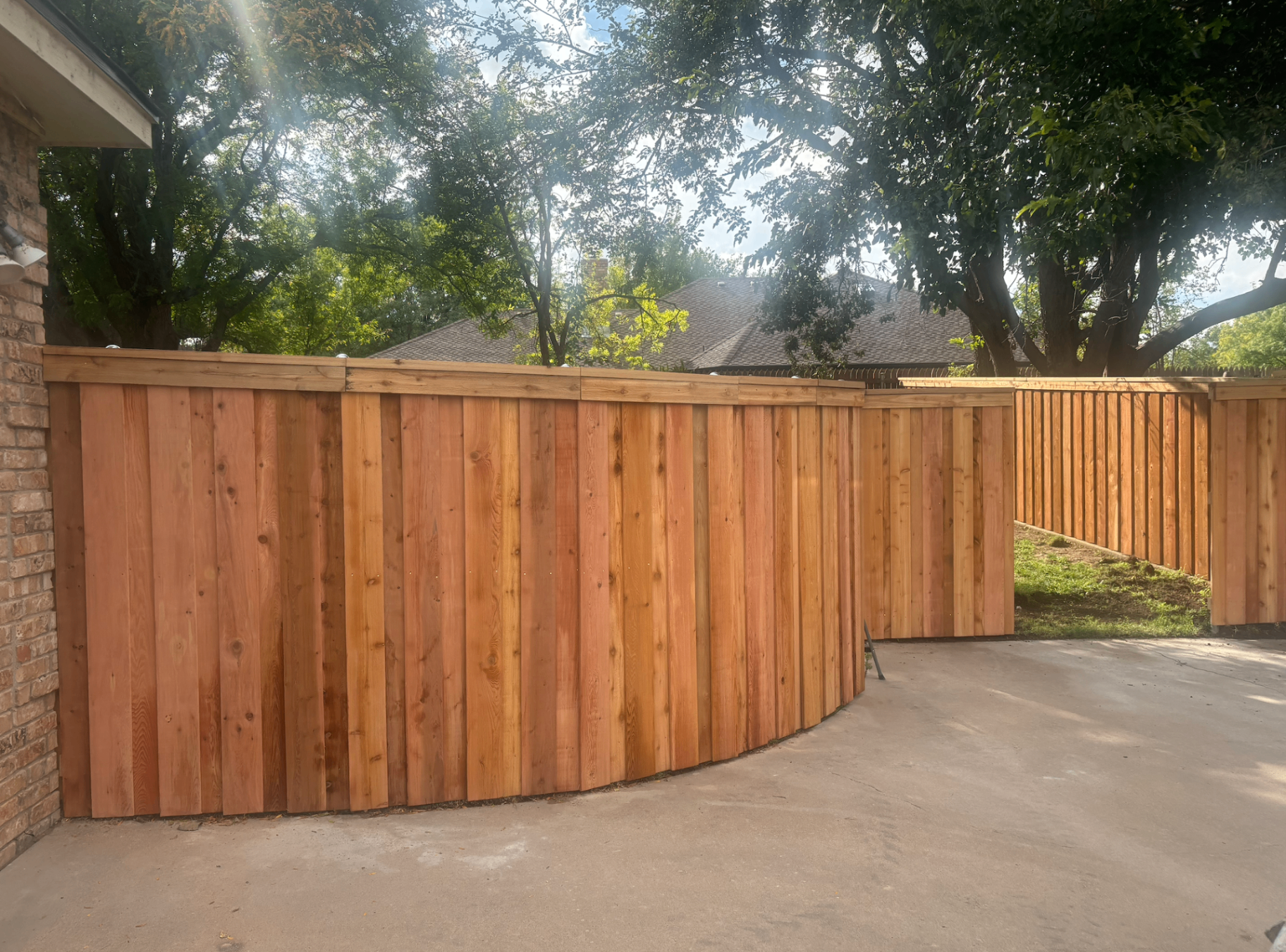 Cedar board-on-board privacy fence along a curved driveway