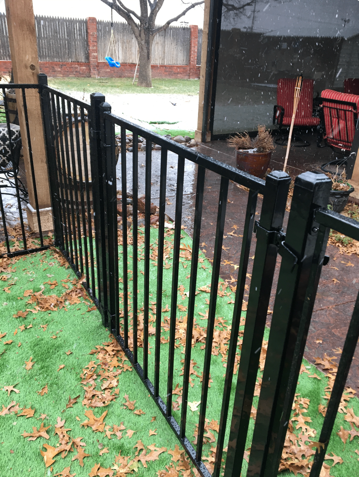 Black ornamental iron fence enclosing a residential patio