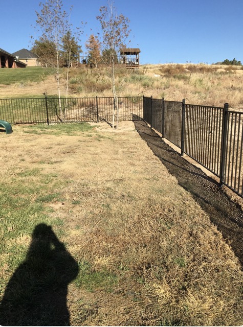 Black ornamental iron fence on a rural Panhandle property