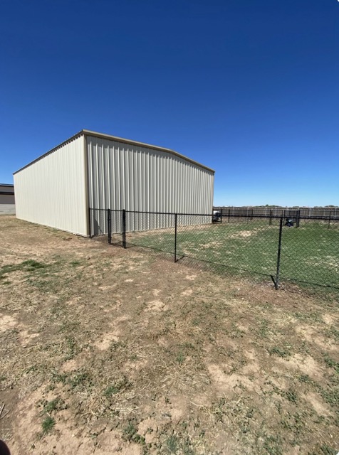 Black chain link perimeter fence around a commercial building
