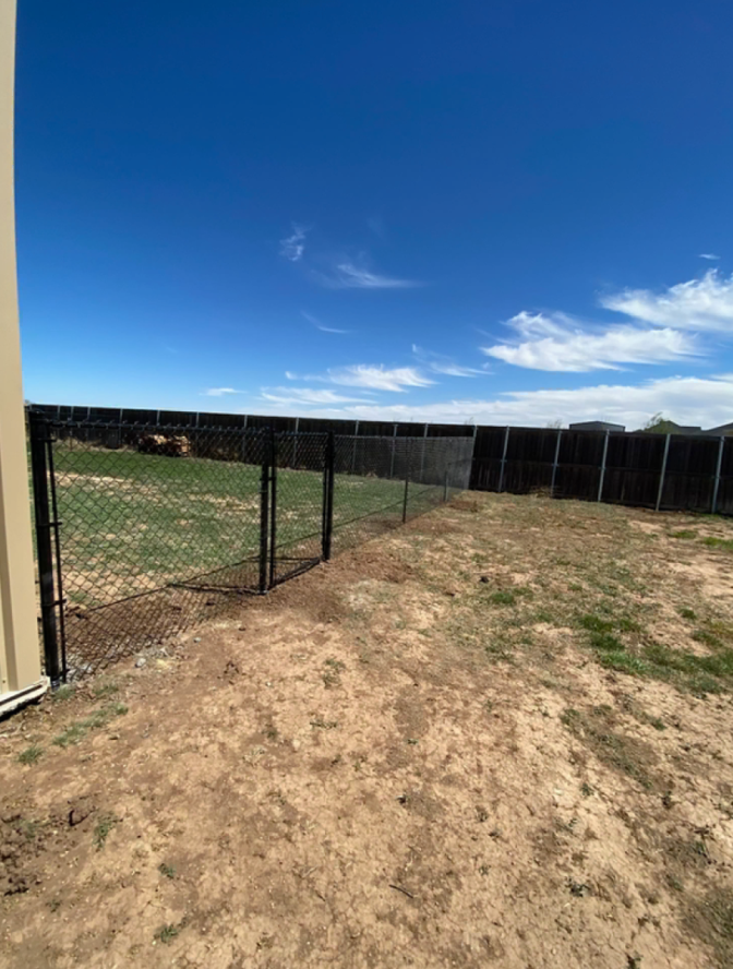 Black chain link perimeter fence around a backyard in Canyon, TX